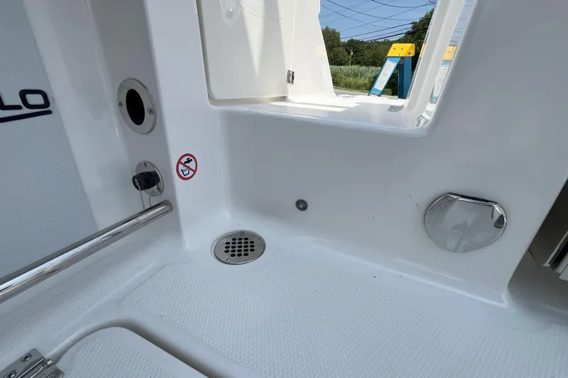  Yacht Photos Pics 2026 Robalo R257 Dual Console boat interior with drain, railing, and storage compartment.