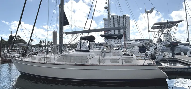 Ruby Lee Yacht Photos Pics 2006 Island Packet 445 sailboat docked at marina, clear sky, modern buildings in background.