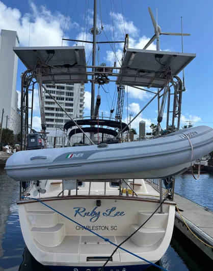 Ruby Lee Yacht Photos Pics 2006 Island Packet 445 sailboat docked, featuring solar panels and a dinghy.