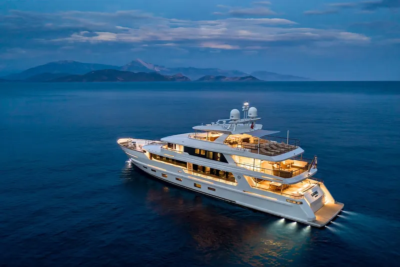Sunrise Yacht Photos Pics Luxurious 2019 Yildiz 141 yacht illuminated at dusk on serene ocean waters.