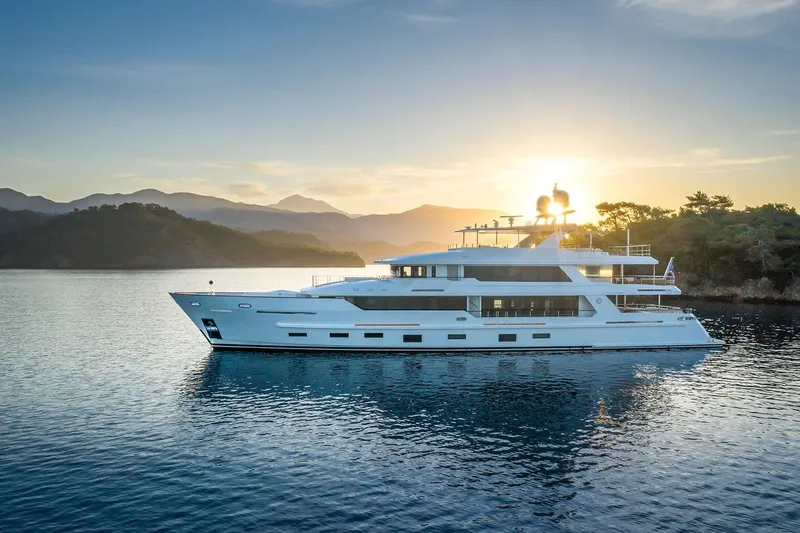 Sunrise Yacht Photos Pics Luxurious 2019 Yildiz 141 yacht at sunset, cruising serene waters with scenic mountain backdrop.