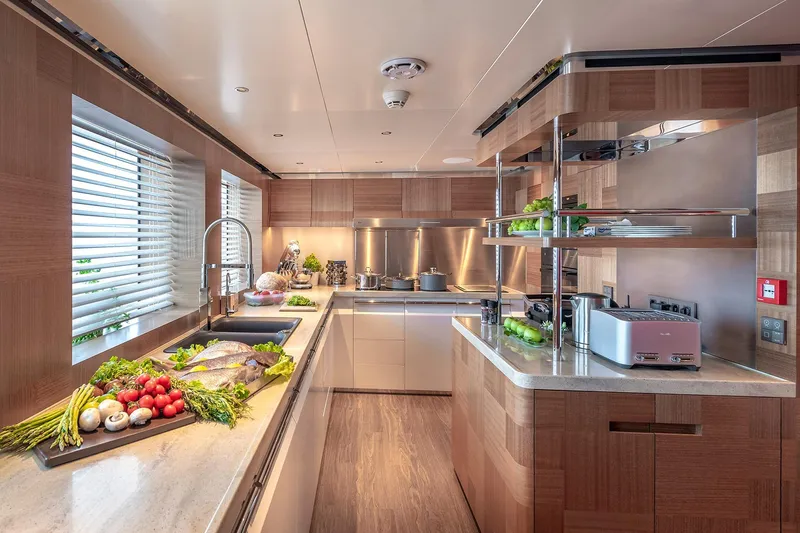 Sunrise Yacht Photos Pics Luxurious yacht kitchen with modern appliances, fresh ingredients, and sleek wooden cabinetry, Yildiz 141, 2019.