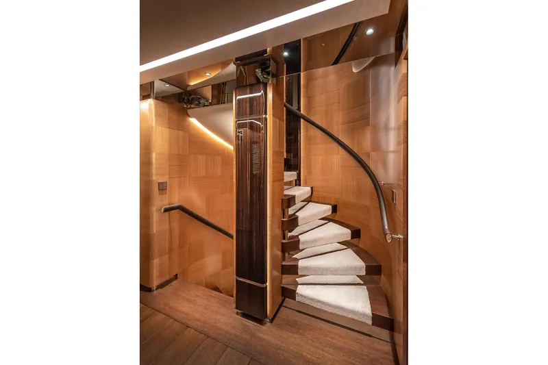 Sunrise Yacht Photos Pics Luxurious wooden spiral staircase on a 2019 Yildiz 141 yacht, featuring elegant lighting.