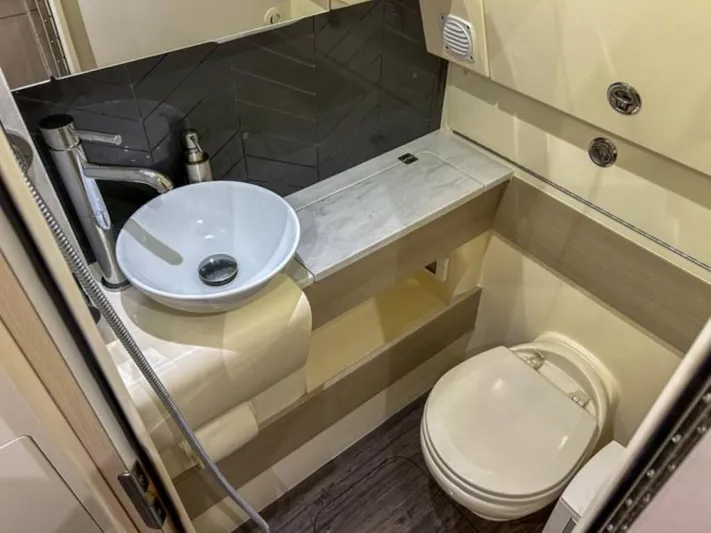  Yacht Photos Pics 2023 Scout 400 LXF boat bathroom with modern sink, toilet, and storage.