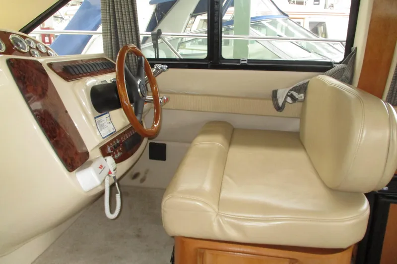 New Lease On Life Yacht Photos Pics 2004 Meridian 340 helm with beige leather seat and wooden steering wheel.