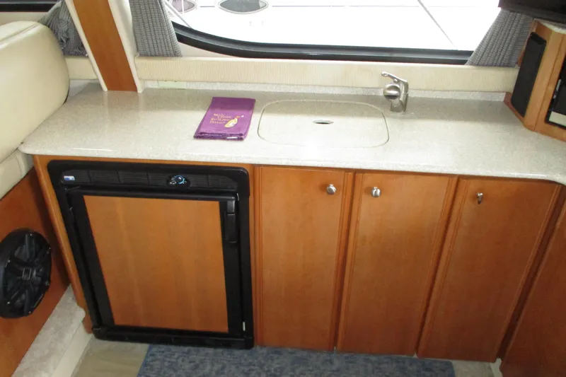 New Lease On Life Yacht Photos Pics 2004 Meridian 340 yacht interior with kitchenette, featuring sink, countertop, and mini fridge.
