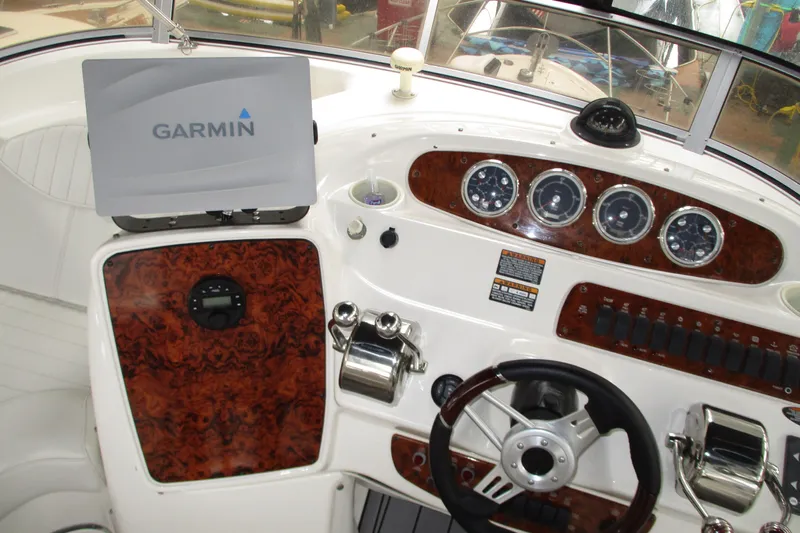 New Lease On Life Yacht Photos Pics 2004 Meridian 340 boat dashboard with Garmin navigation system and wood paneling.