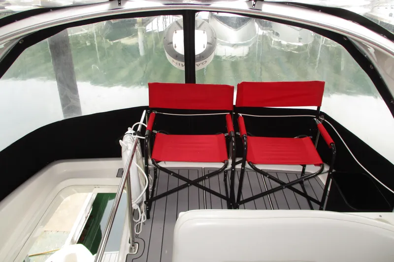 New Lease On Life Yacht Photos Pics Red chairs on 2004 Meridian 340 boat deck with clear canopy.