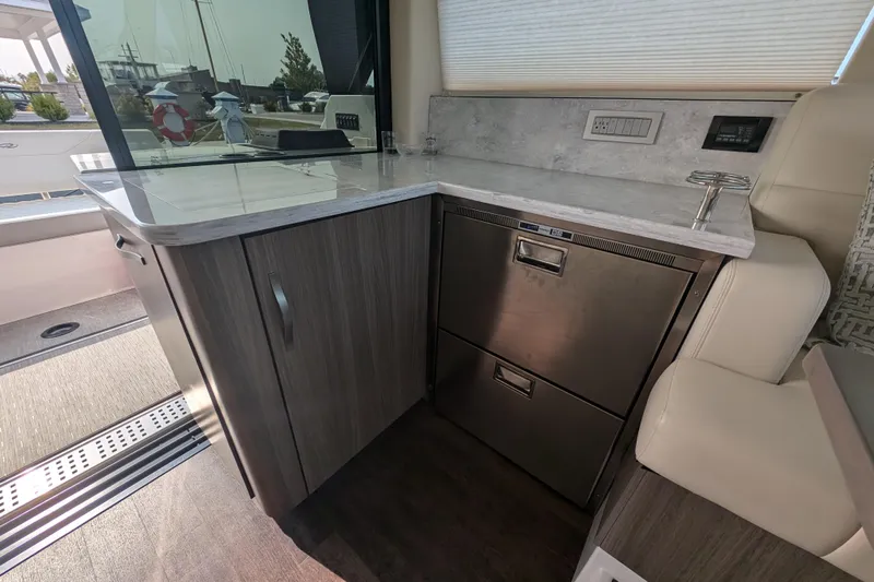  Yacht Photos Pics 2020 Regal 38 Grande Coupe yacht interior with modern kitchenette and stainless steel appliances.