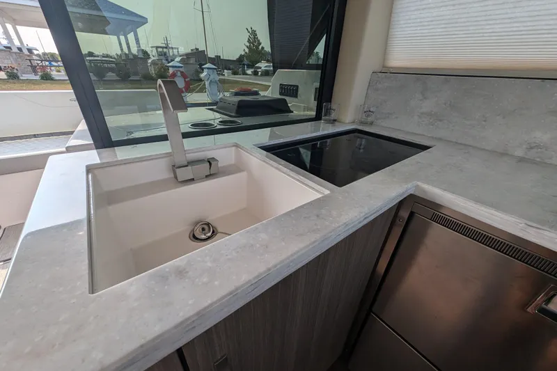  Yacht Photos Pics Modern kitchen area in a 2020 Regal 38 Grande Coupe yacht with sink and stovetop.