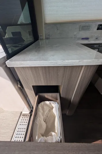  Yacht Photos Pics 2020 Regal 38 Grande Coupe interior with modern kitchen counter and pull-out trash bin.