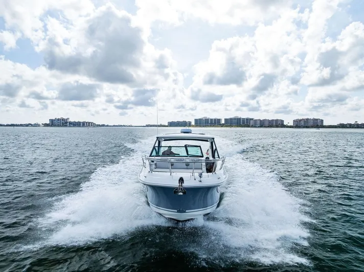 Swelltimes IV Yacht Photos Pics 2022 Sea Ray Sundancer 320 OB cruising on open water under a cloudy sky.