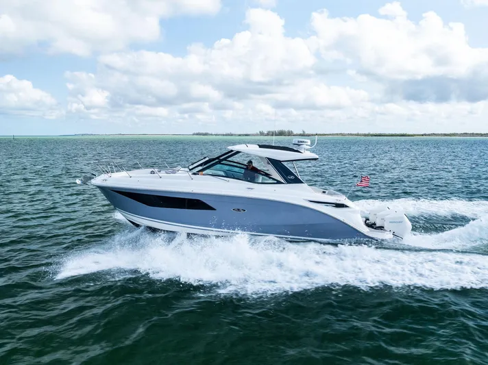 Swelltimes IV Yacht Photos Pics 2022 Sea Ray Sundancer 320 OB cruising on open water under a partly cloudy sky.