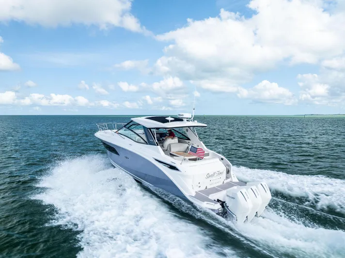 Swelltimes IV Yacht Photos Pics 2022 Sea Ray Sundancer 320 OB cruising on open water under a clear blue sky.