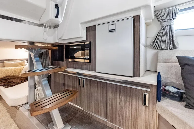 Swelltimes IV Yacht Photos Pics 2022 Sea Ray Sundancer 320 OB interior with modern kitchenette and cozy seating area.