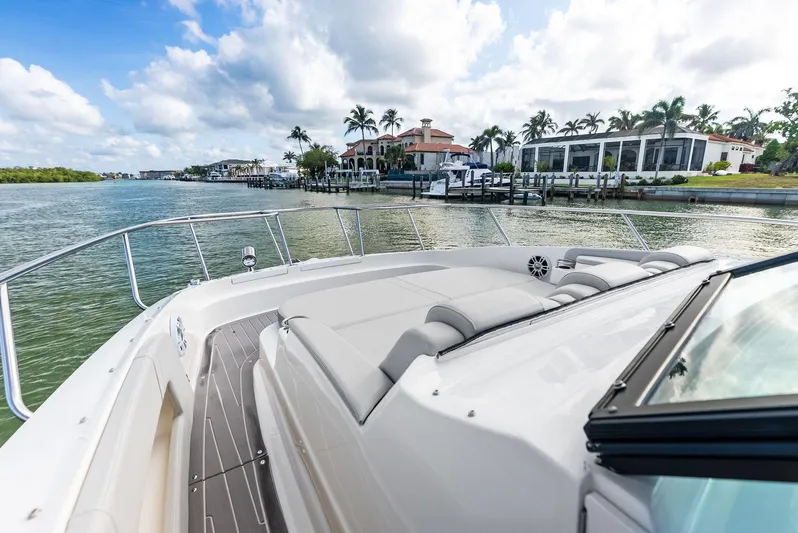 Swelltimes IV Yacht Photos Pics 2022 Sea Ray Sundancer 320 OB cruising near waterfront homes under a partly cloudy sky.
