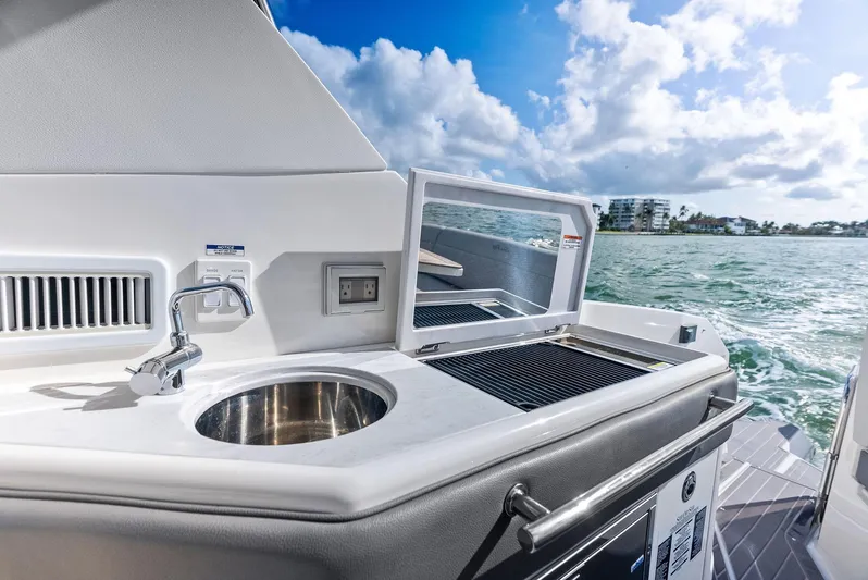 Swelltimes IV Yacht Photos Pics Outdoor kitchenette on 2022 Sea Ray Sundancer 320 OB yacht with sink and grill, ocean view.