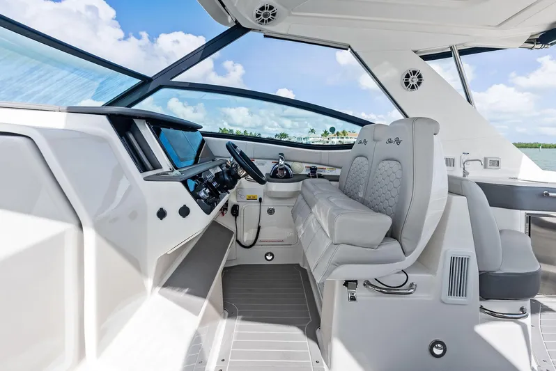 Swelltimes IV Yacht Photos Pics 2022 Sea Ray Sundancer 320 OB cockpit with modern helm and seating under blue sky.