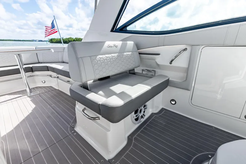 Swelltimes IV Yacht Photos Pics 2022 Sea Ray Sundancer 320 OB interior with seating, American flag, and scenic view.