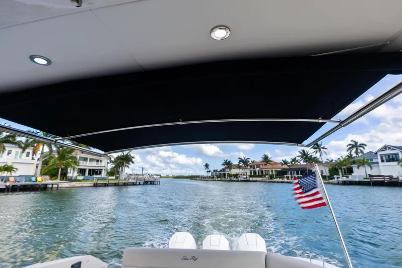 Swelltimes IV Yacht Photos Pics 2022 Sea Ray Sundancer 320 OB cruising on a scenic waterway with American flag.