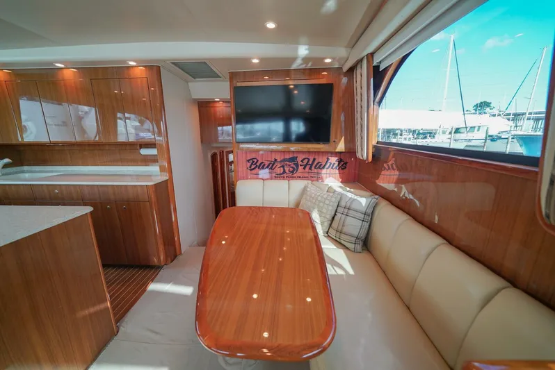 Bad Habits Yacht Photos Pics Luxurious interior of 2007 Viking 45 Convertible yacht with wood finishes and seating area.