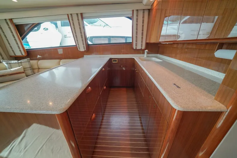 Bad Habits Yacht Photos Pics Luxurious interior of 2007 Viking 45 Convertible yacht with sleek countertops and wood finish.
