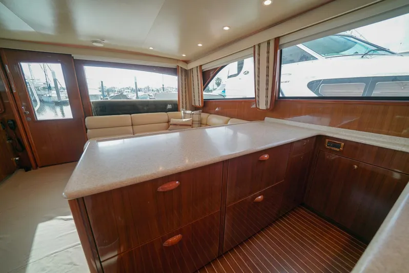 Bad Habits Yacht Photos Pics Luxurious interior of 2007 Viking 45 Convertible yacht with wood cabinetry and seating area.