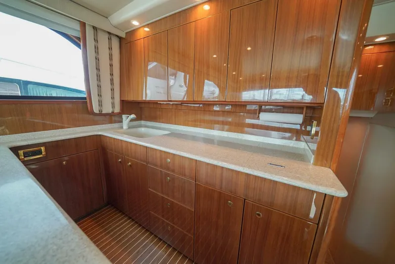 Bad Habits Yacht Photos Pics Luxurious kitchen interior of 2007 Viking 45 Convertible yacht with wooden cabinetry.