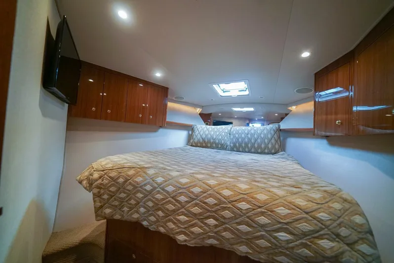 Bad Habits Yacht Photos Pics Luxurious cabin interior of 2007 Viking 45 Convertible yacht with cozy bed and wooden cabinets.