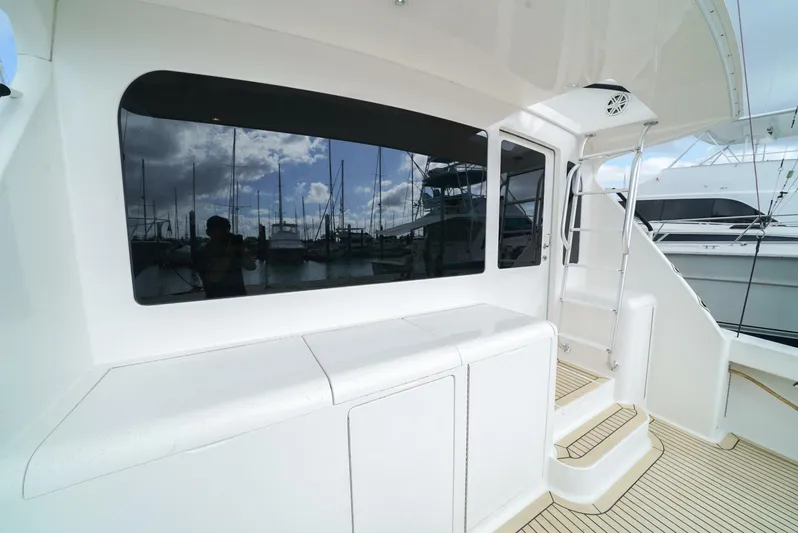 Bad Habits Yacht Photos Pics 2007 Viking 45 Convertible yacht with sleek white exterior and marina reflection.