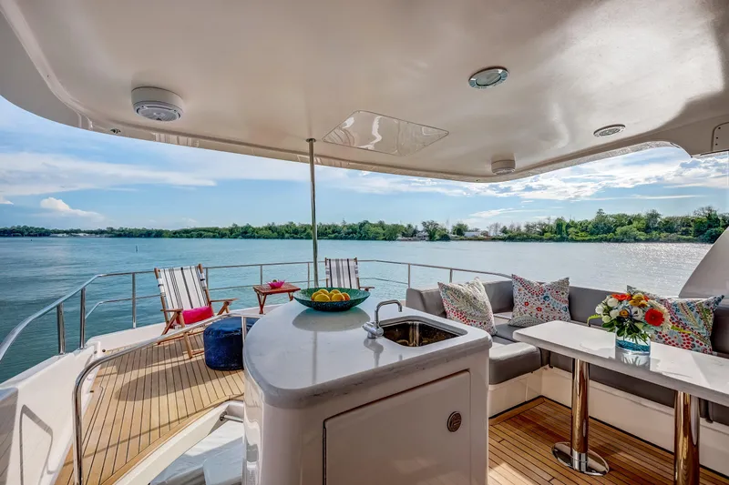 Family Tradition II Yacht Photos Pics Luxurious Neptunus 750FX yacht deck with seating, table, and scenic water view, 2012 model.