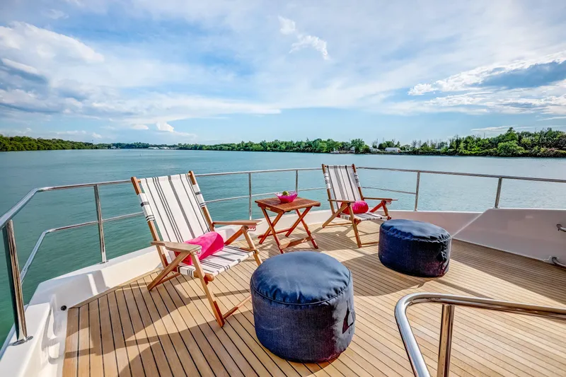 Family Tradition II Yacht Photos Pics Deck of 2012 Neptunus 750FX yacht with chairs, tables, and scenic water view.