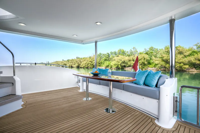 Family Tradition II Yacht Photos Pics Luxurious Neptunus 750FX yacht deck with seating, table, and scenic river view.