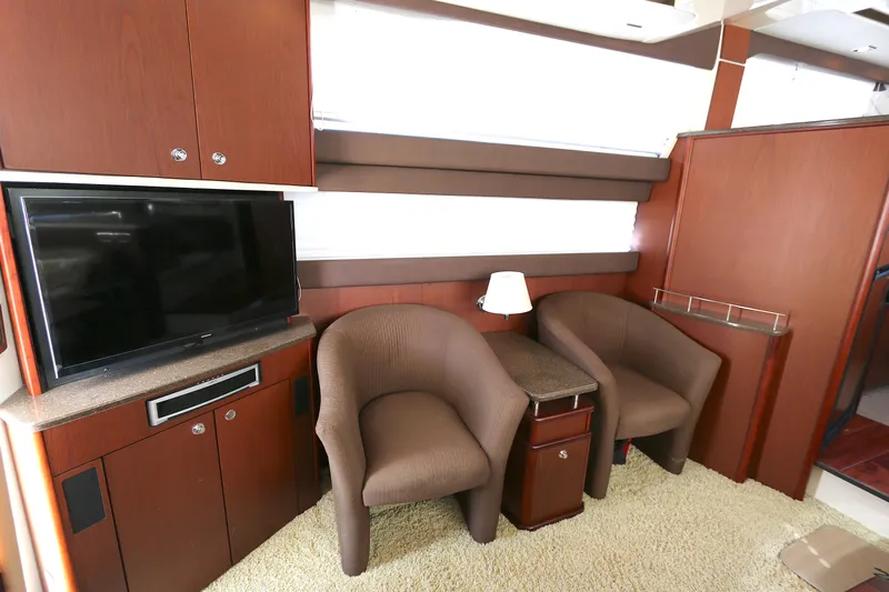 Family Time Yacht Photos Pics Interior of 2013 Meridian 441 Sedan with TV, chairs, and wooden cabinetry.