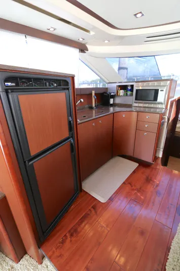 Family Time Yacht Photos Pics 2013 Meridian 441 Sedan yacht kitchen with wood flooring, fridge, microwave, and modern cabinetry.