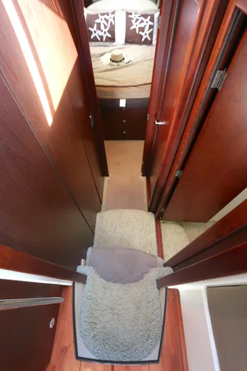 Family Time Yacht Photos Pics Interior hallway of 2013 Meridian 441 Sedan yacht with carpeted steps and wooden paneling.