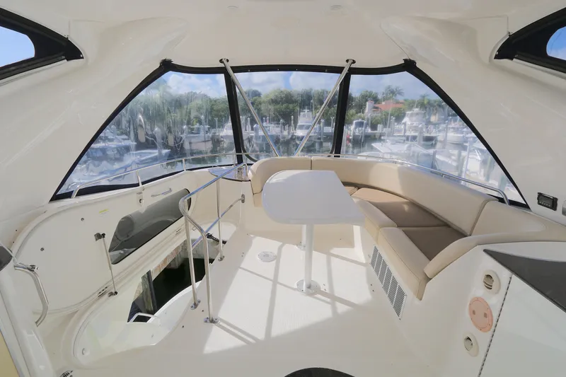 Family Time Yacht Photos Pics Interior of 2013 Meridian 441 Sedan yacht with seating and table, overlooking marina.