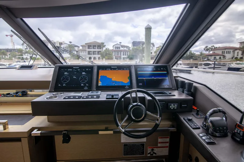 Prestige Worldwide Yacht Photos Pics Cockpit of 2018 Prestige 680 Flybridge yacht with navigation screens and steering wheel.
