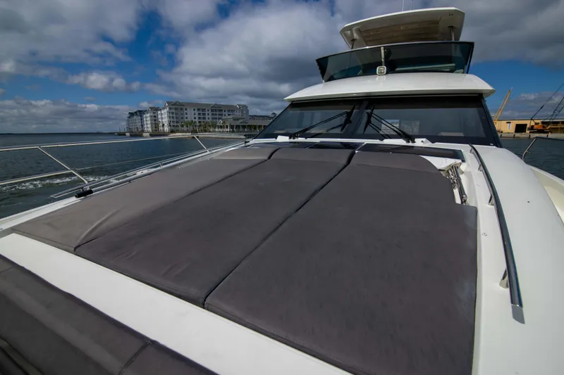Prestige Worldwide Yacht Photos Pics 2018 Prestige 680 Flybridge yacht with spacious deck, docked near waterfront buildings.