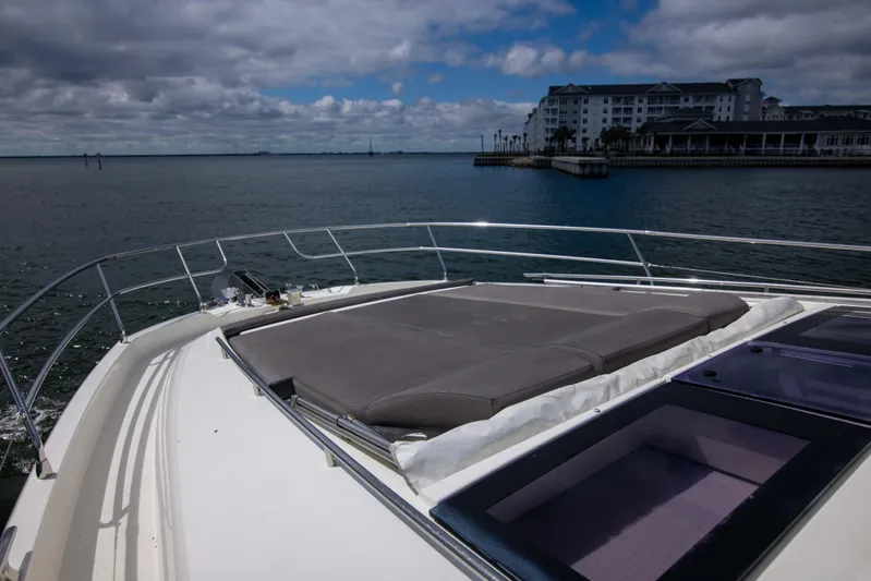 Prestige Worldwide Yacht Photos Pics Prestige 680 Flybridge 2018 yacht with sunpad, overlooking calm waters and distant buildings.