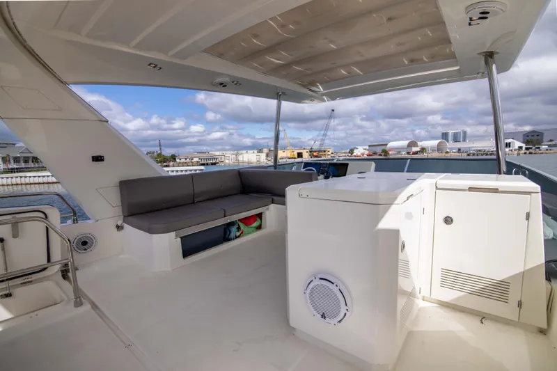 Prestige Worldwide Yacht Photos Pics Flybridge of 2018 Prestige 680 yacht with seating and storage, under a partly cloudy sky.