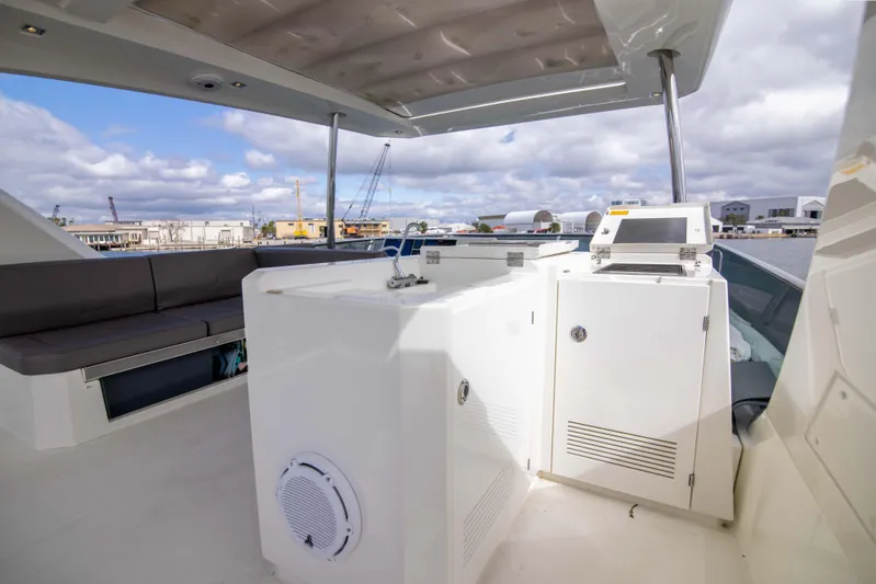 Prestige Worldwide Yacht Photos Pics Flybridge of 2018 Prestige 680 yacht with seating and control panel under cloudy sky.