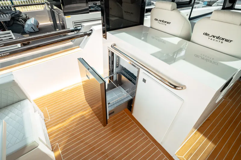  Yacht Photos Pics 2025 De Antonio Yachts D50 Coupé interior with open mini-fridge and luxurious seating.