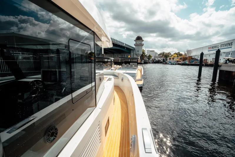  Yacht Photos Pics 2025 De Antonio Yachts D50 Coupé docked by a waterfront under cloudy skies.