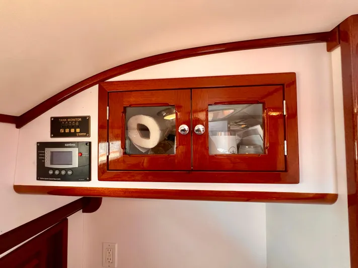 Indigo Yacht Photos Pics Wooden cabinet with glass doors in a 2007 Bruckmann 34e boat interior.