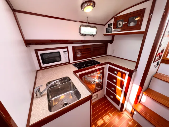 Indigo Yacht Photos Pics Luxurious 2007 Bruckmann 34e yacht kitchen with modern appliances and elegant wood finish.