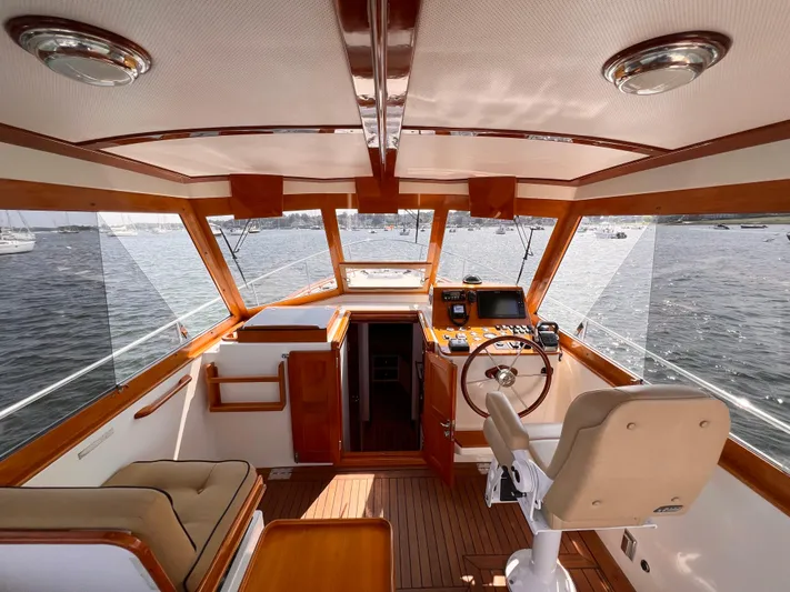 Indigo Yacht Photos Pics Interior of 2007 Bruckmann 34e yacht with wooden accents and steering wheel.
