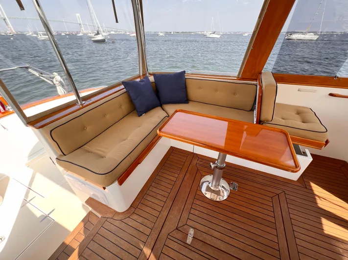 Indigo Yacht Photos Pics Luxurious seating area on 2007 Bruckmann 34e yacht with wooden table and cushions.