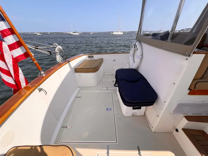 Indigo Yacht Photos Pics Bruckmann 34e 2007 boat deck with seating, American flag, and ocean view.