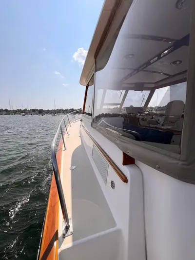 Indigo Yacht Photos Pics 2007 Bruckmann 34e yacht on water, side view with cabin and railing.